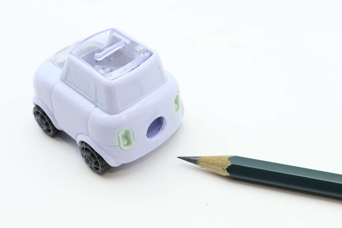 車型鉛筆削りと、きれいに削られた鉛筆が並んで置かれている 車型鉛筆削りと、きれいに削られた鉛筆が並んで置かれている