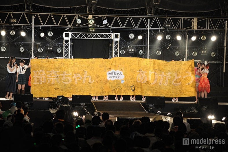 メンバーとファンが寄せ書きしたフラッグをプレゼント