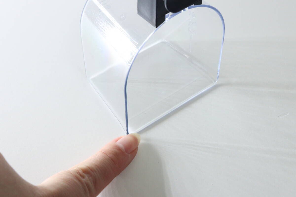 計量カップの底がフラットな形状であることを指で示している 計量カップの底がフラットな形状であることを指で示している