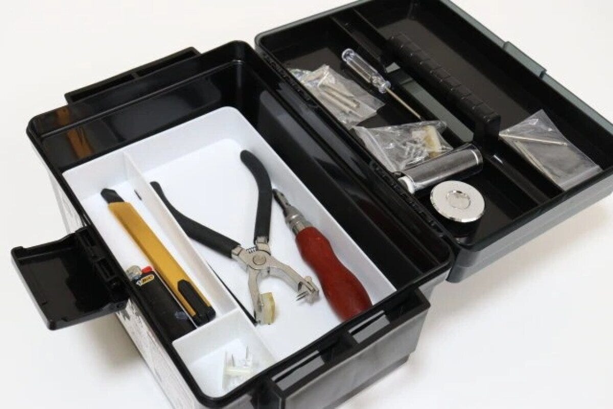 開いたタックルボックスに工具や小物が収納されている