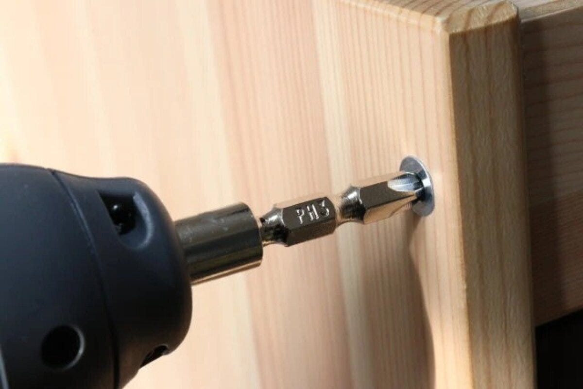 電動ドライバーで木製家具のネジを締めている様子