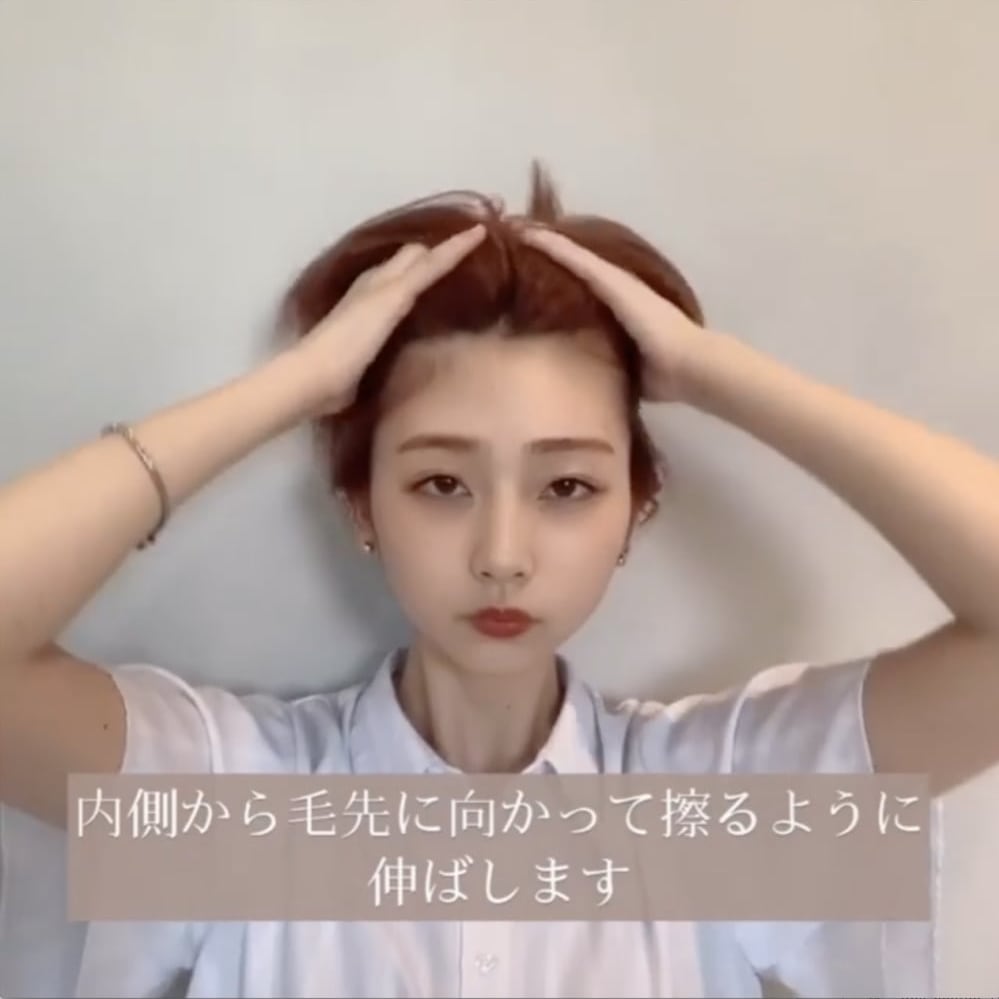 内側から毛先に向かってスタイリング剤をつけている写真