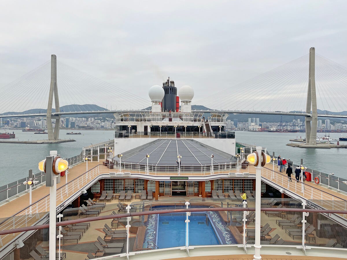 外国船は日本発着クルーズでも海外都市に寄港する。こちらの写真は2023年4月23日に釜山（韓国）を出港したところ。ハーバーブリッジはギリギリくぐることができる高さ