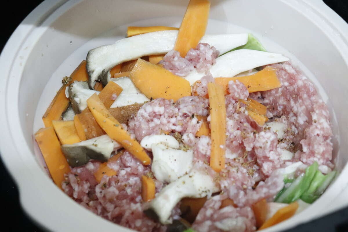 スチーマーにひき肉と野菜を入れ調味料を振る スチーマーにひき肉と野菜を入れ調味料を振る