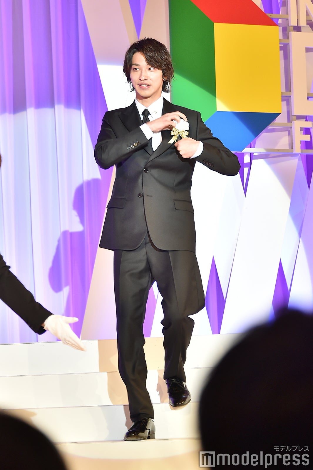 胸ポケットの花が落ちてしまい拾った横浜流星 （C）モデルプレス