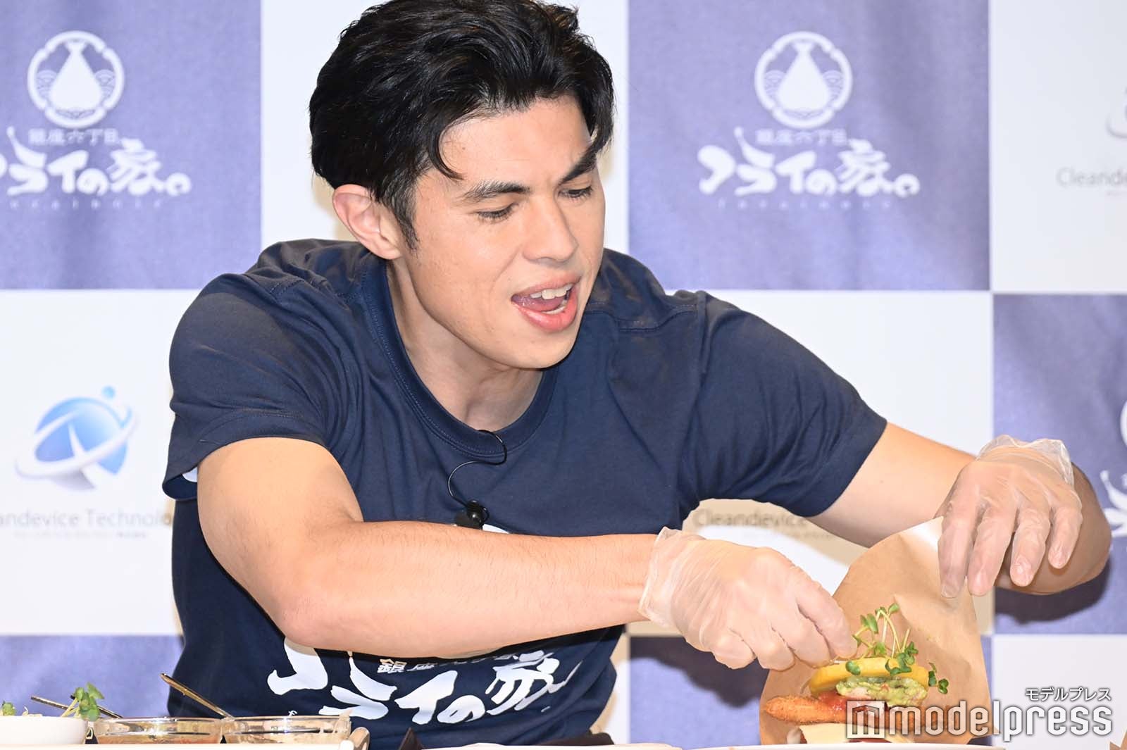 ハンバーガーを手に取ろうとする小島よしお （C）モデルプレス