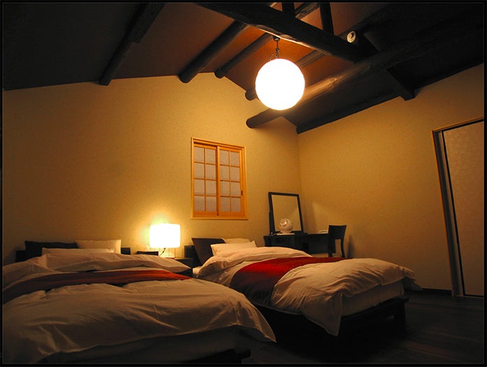 太い梁を見上げる客室／「城巽 あかね庵」オフィシャルサイトより