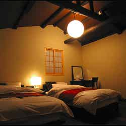 太い梁を見上げる客室/「城巽 あかね庵」オフィシャルサイトより