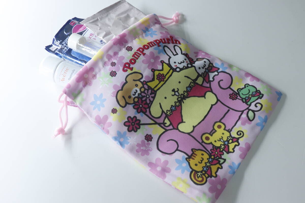 ポムポムプリンの巾着に化粧水やシートなどのケア用品を入れている ポムポムプリンの巾着に化粧水やシートなどのケア用品を入れている