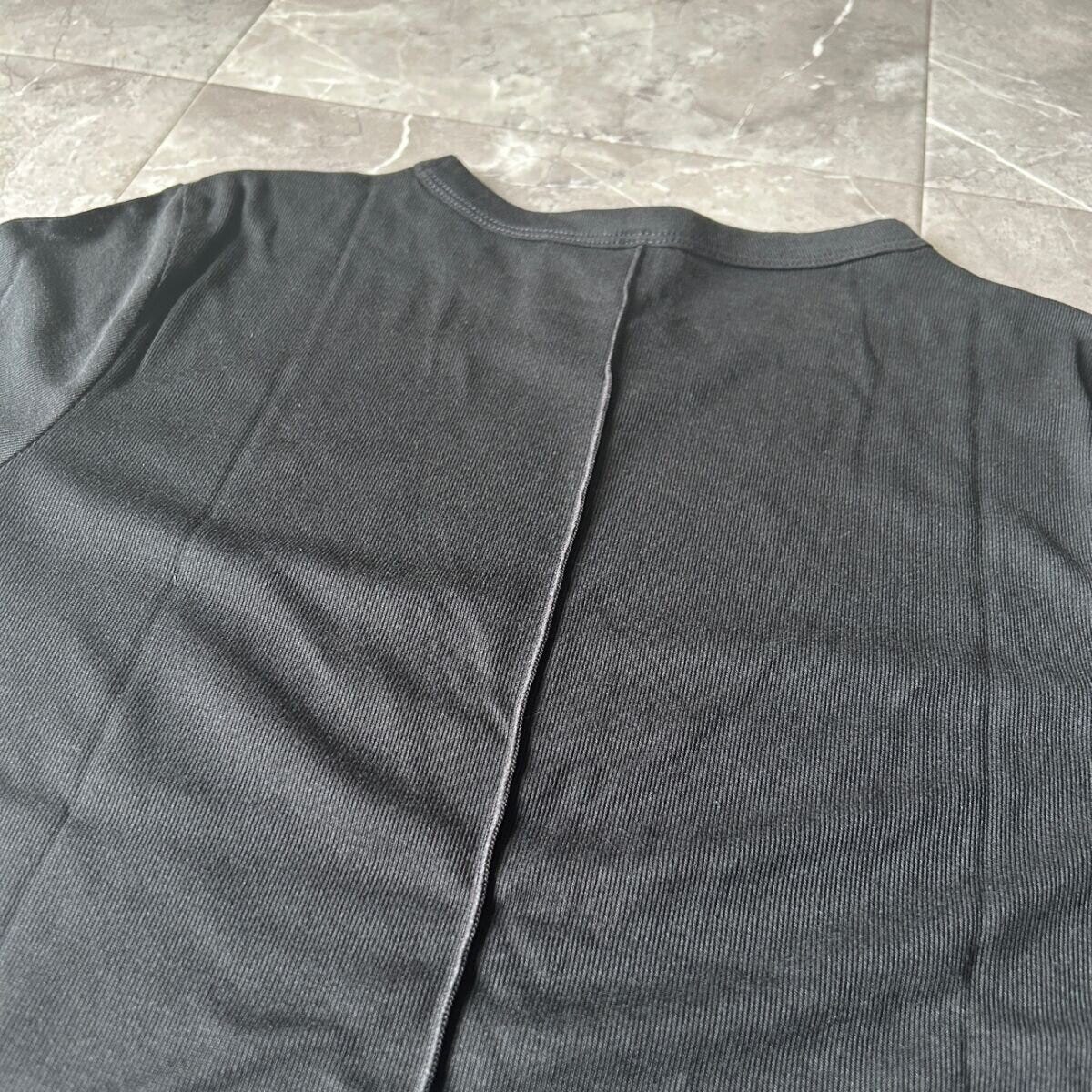 黒いシアーTシャツの背中部分にあるメローデザインの縫い目をアップで写している