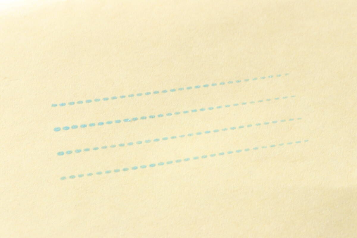 薄茶色の紙に水色の点線でスタンプされた罫線