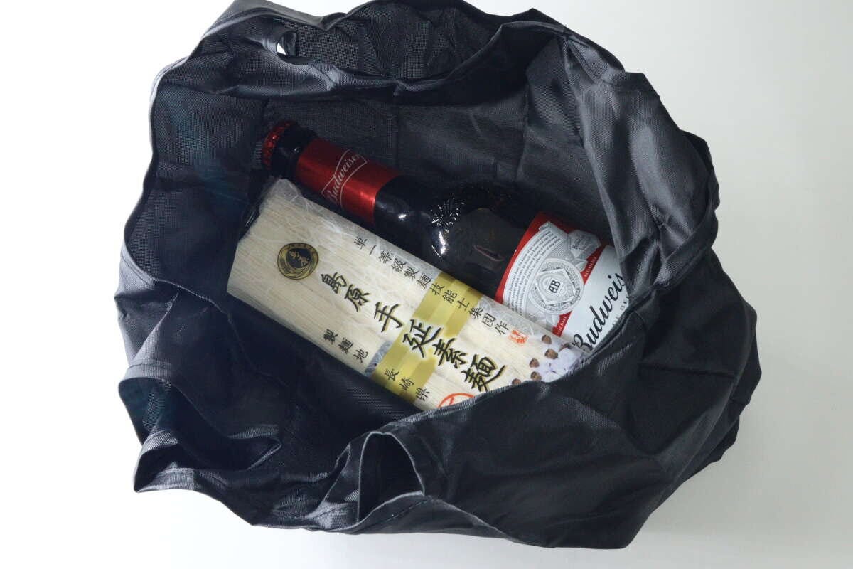 広げたエコバッグにそうめんと瓶ビールを入れた様子