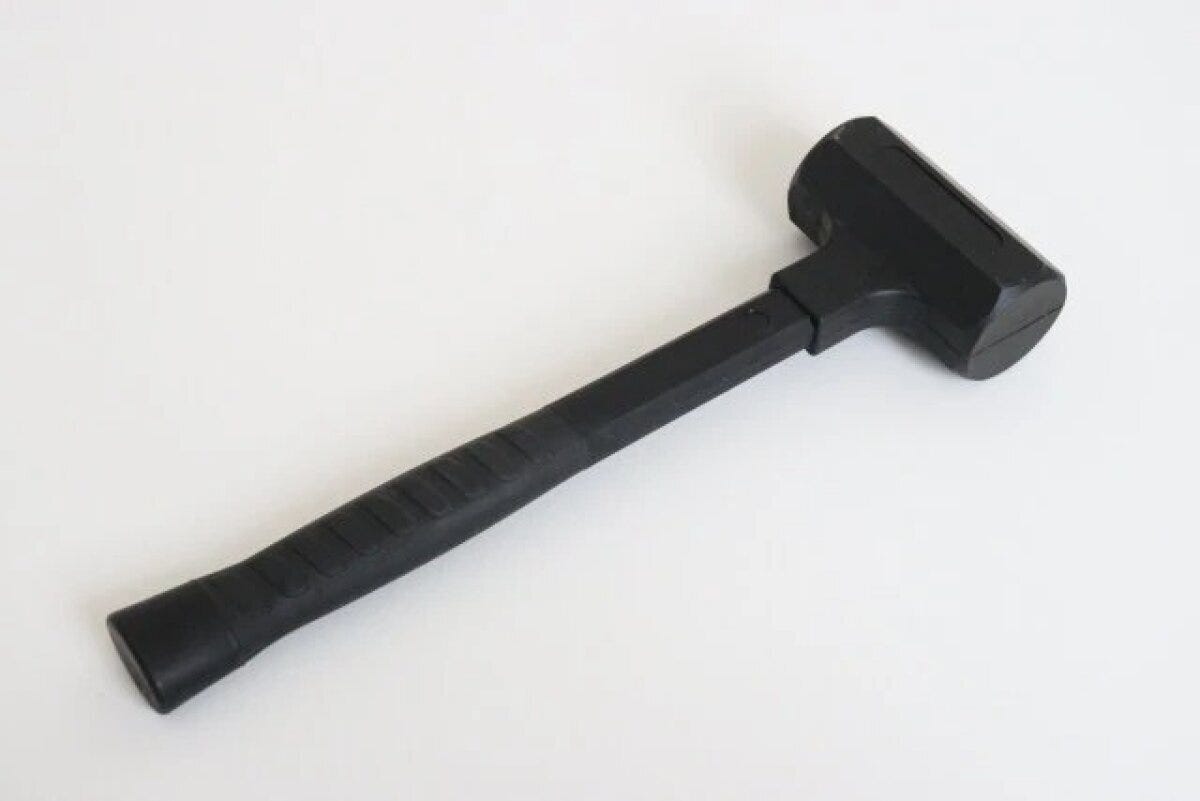 黒いショックレスハンマーが白い背景に置かれている