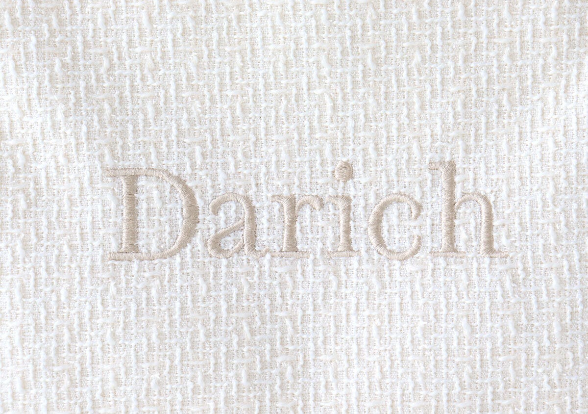 アイボリーのツイード生地にベージュのDarichロゴ刺繍