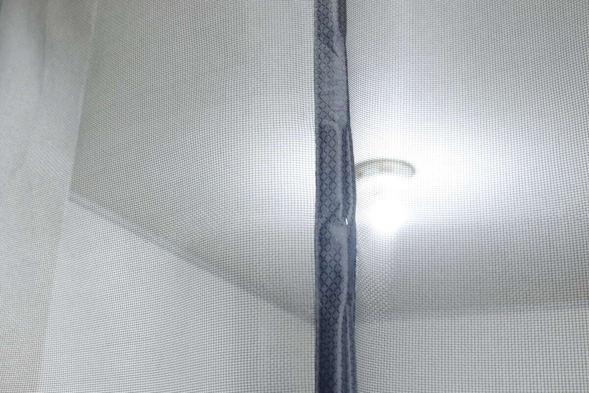 網戸越しに部屋の奥の照明が見える様子で、透過性がわかる