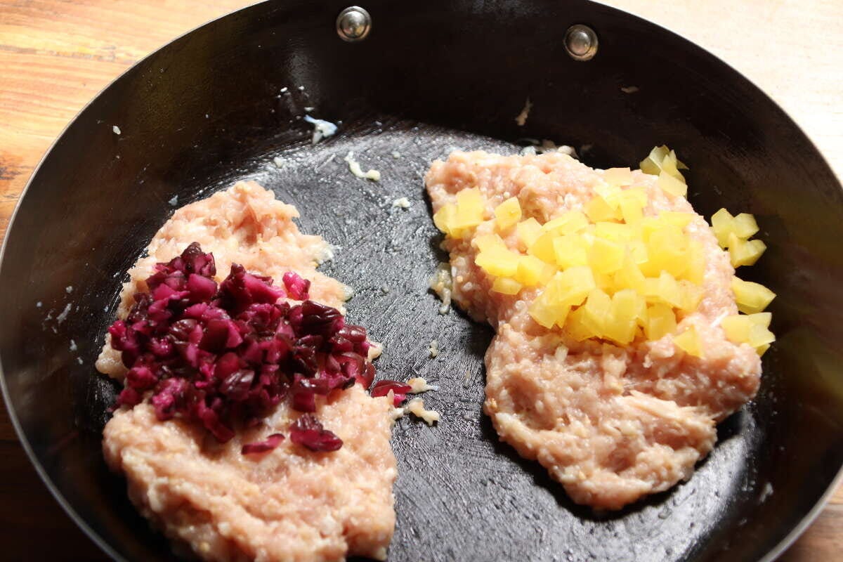 フライパンの中で、鶏ひき肉に刻んだしば漬けとたくあんをそれぞれ混ぜて2種類のつくねを作っている