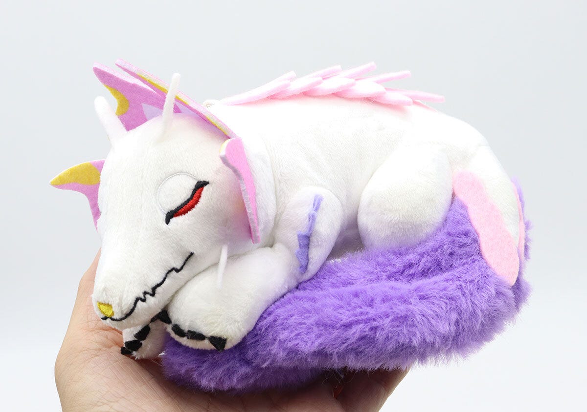 手のひらに乗せられた、すやすや眠るタマミツネのぬいぐるみチャーム 手のひらに乗せられた、すやすや眠るタマミツネのぬいぐるみチャーム