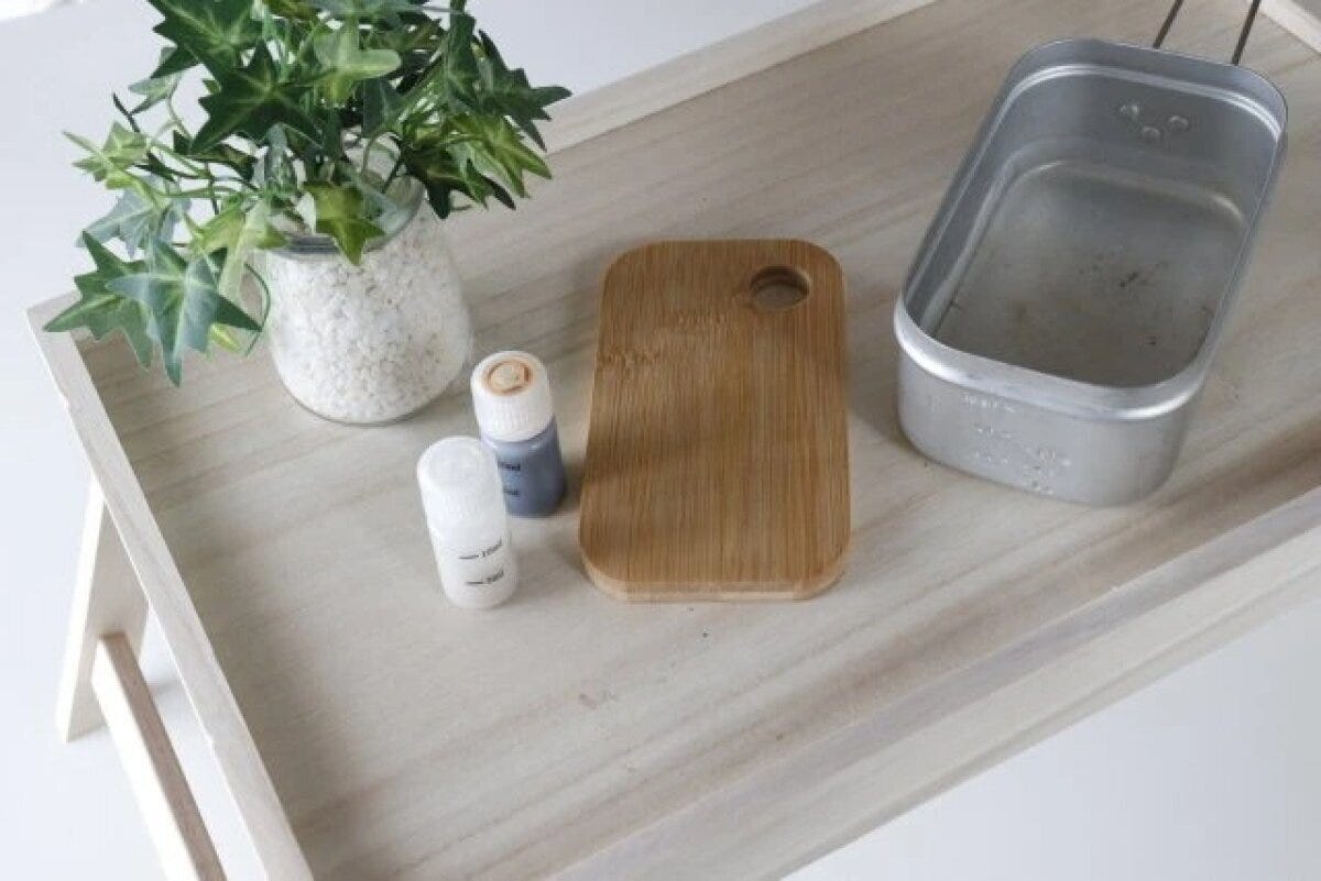 折りたたみテーブルに観葉植物やアウトドア用品が置かれている