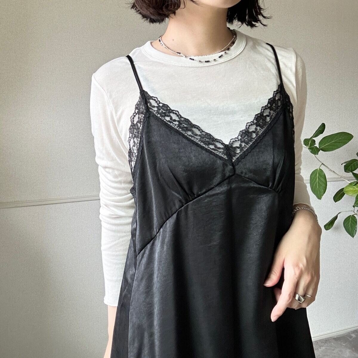 白いロンTと黒いサテンキャミソールを重ね着した女性の胸元アップ 白いロンTと黒いサテンキャミソールを重ね着した女性の胸元アップ