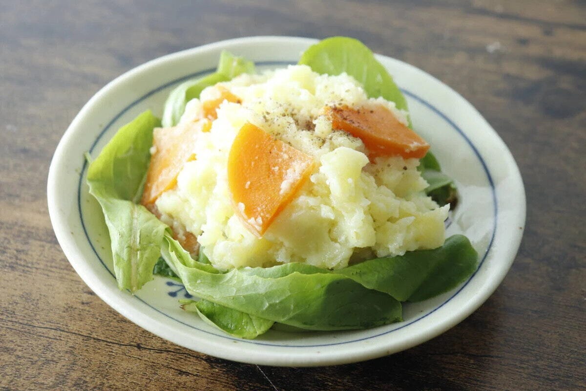 レタスの上にポテトサラダと人参が盛り付けられた白い皿 レタスの上にポテトサラダと人参が盛り付けられた白い皿