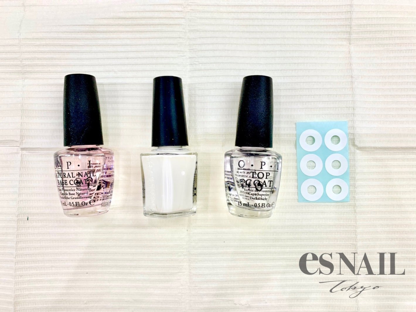 （左から）ベースコート、白のポリッシュ、トップコート、パンチ穴補強シール（画像提供：esNAIL）