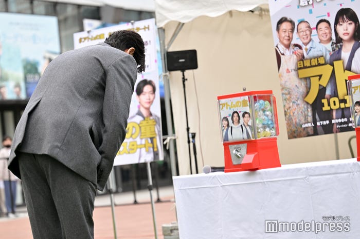 カプセルトイにお辞儀をする松下洸平(C)モデルプレス