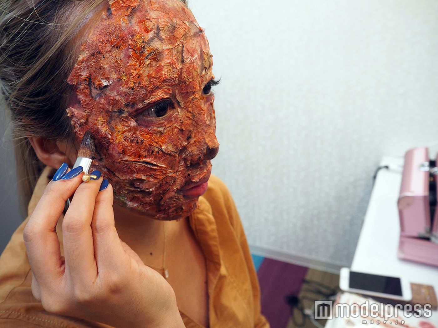 8)血のりを筆にとって顔全体に塗っていく