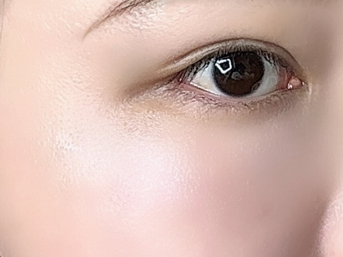 女性の目元と頬に塗布されツヤが出ている様子