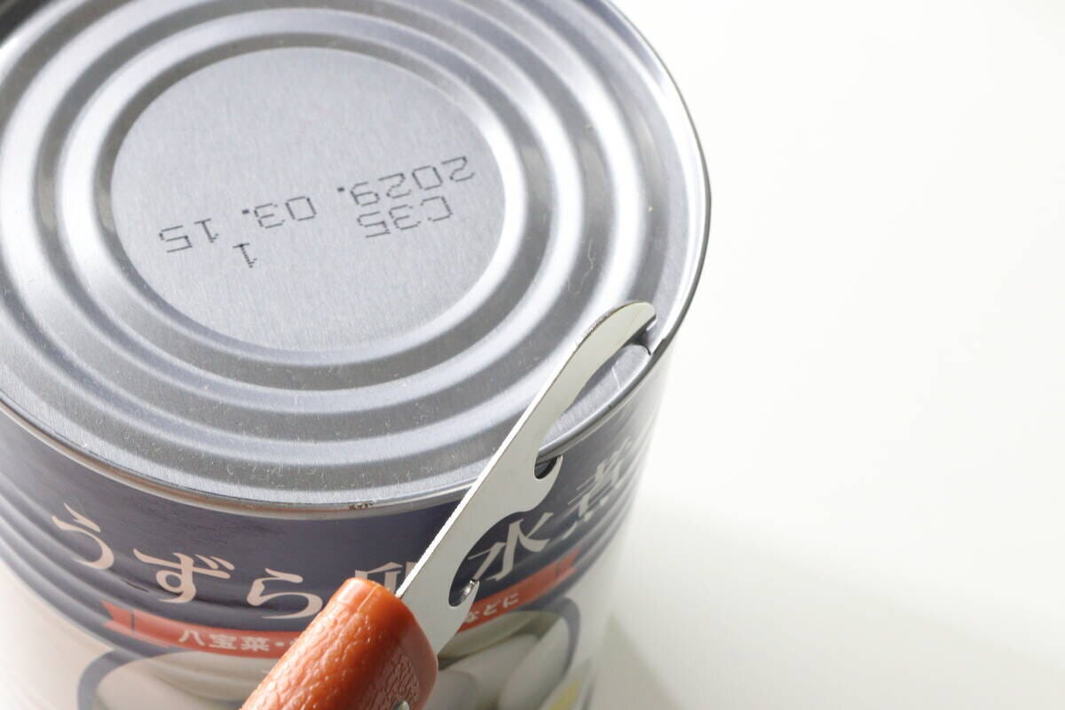 折りたたみナイフの缶切りで缶詰の蓋を開ける