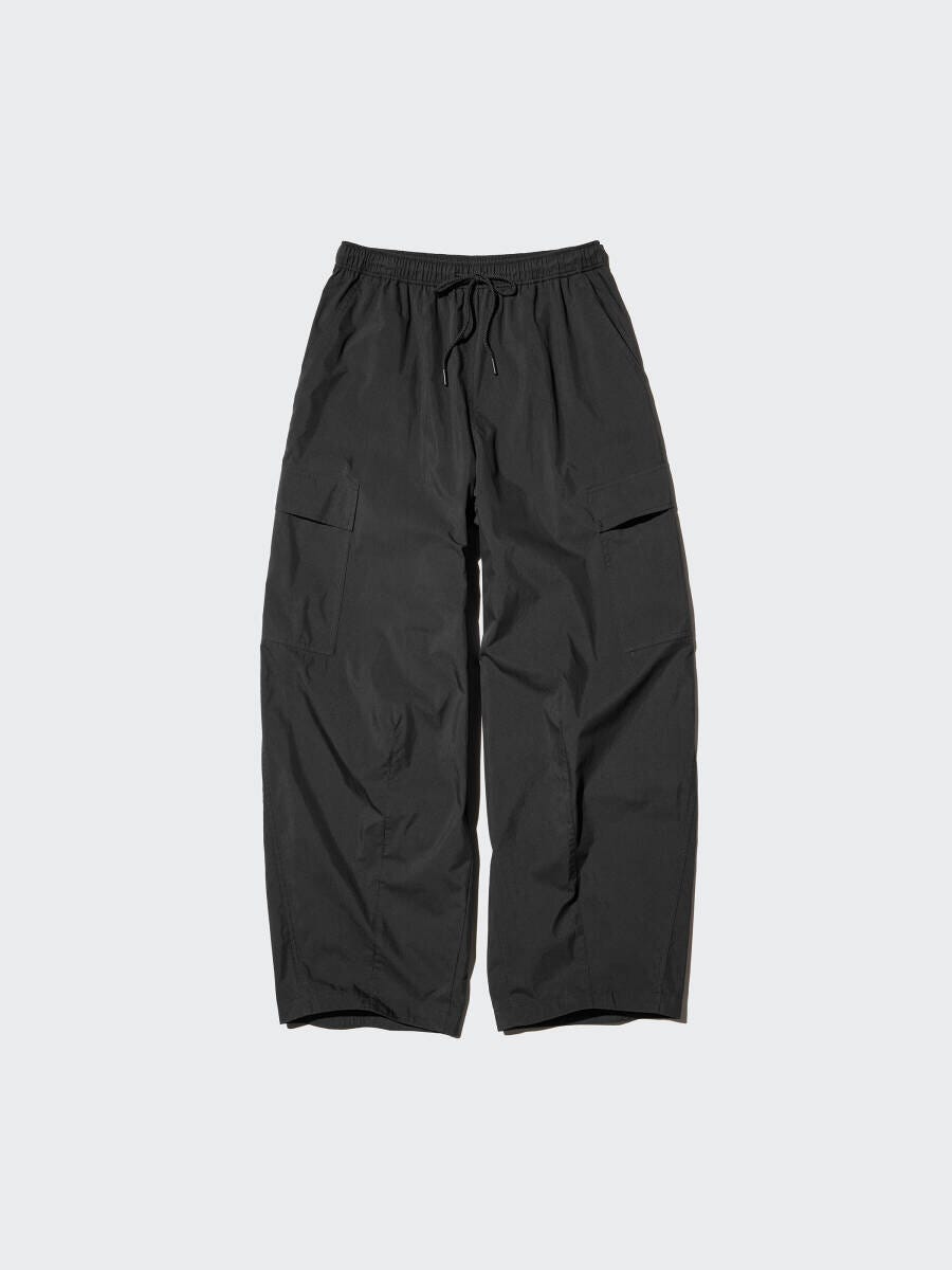 黒いユーティリティボリュームパンツ。ウエストゴムと紐、サイドにフラップポケット。 黒いユーティリティボリュームパンツ。ウエストゴムと紐、サイドにフラップポケット。