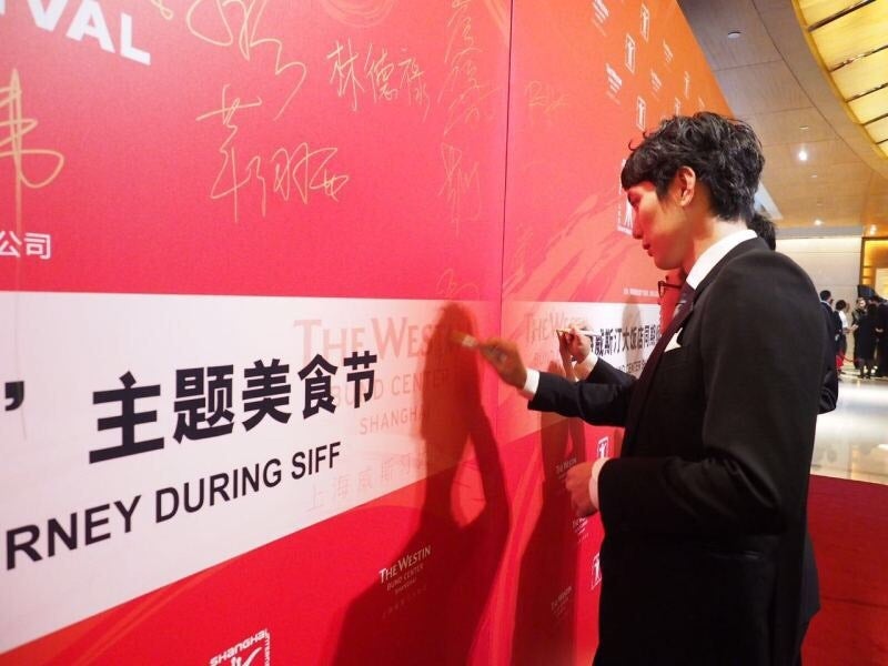 パネルにサインを書く平岡祐太