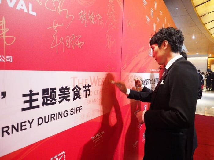 パネルにサインを書く平岡祐太