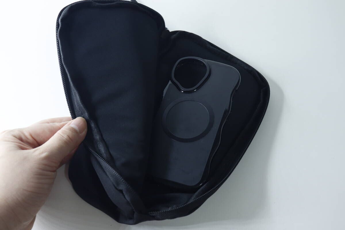 ポーチの中に黒いスマートフォンケースを入れている