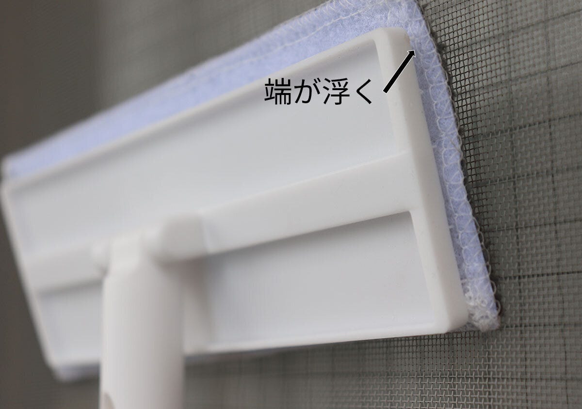 網戸に当てた「首振り網戸クリーナー」のヘッドの端が浮いている状態のアップ