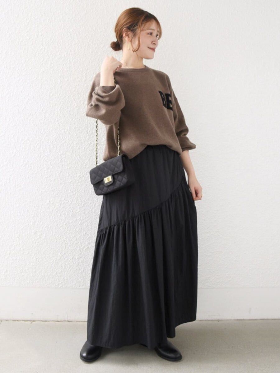 ブラウンのロゴニットと黒のティアードスカートのコーデ