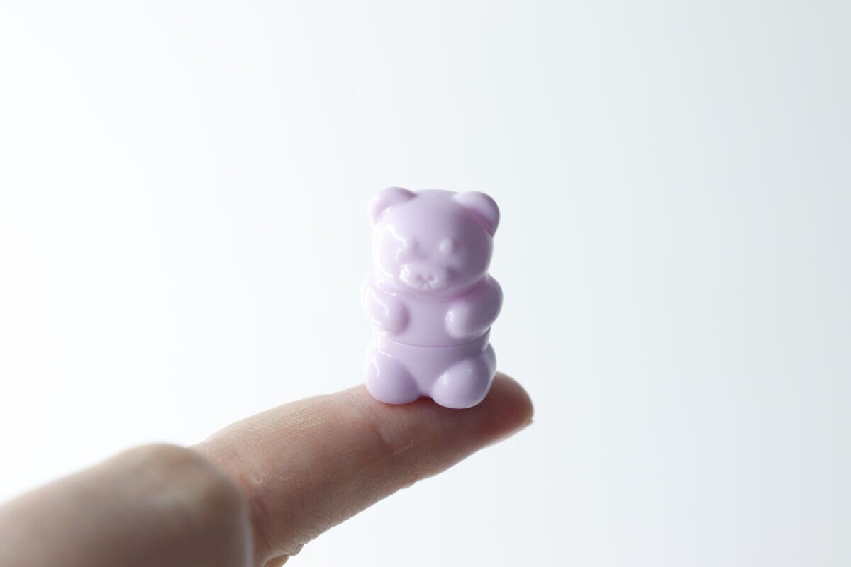 指先にちょこんと乗せられた、くまちゃん形のミニリップブラシ。その小ささがわかる 指先にちょこんと乗せられた、くまちゃん形のミニリップブラシ。その小ささがわかる