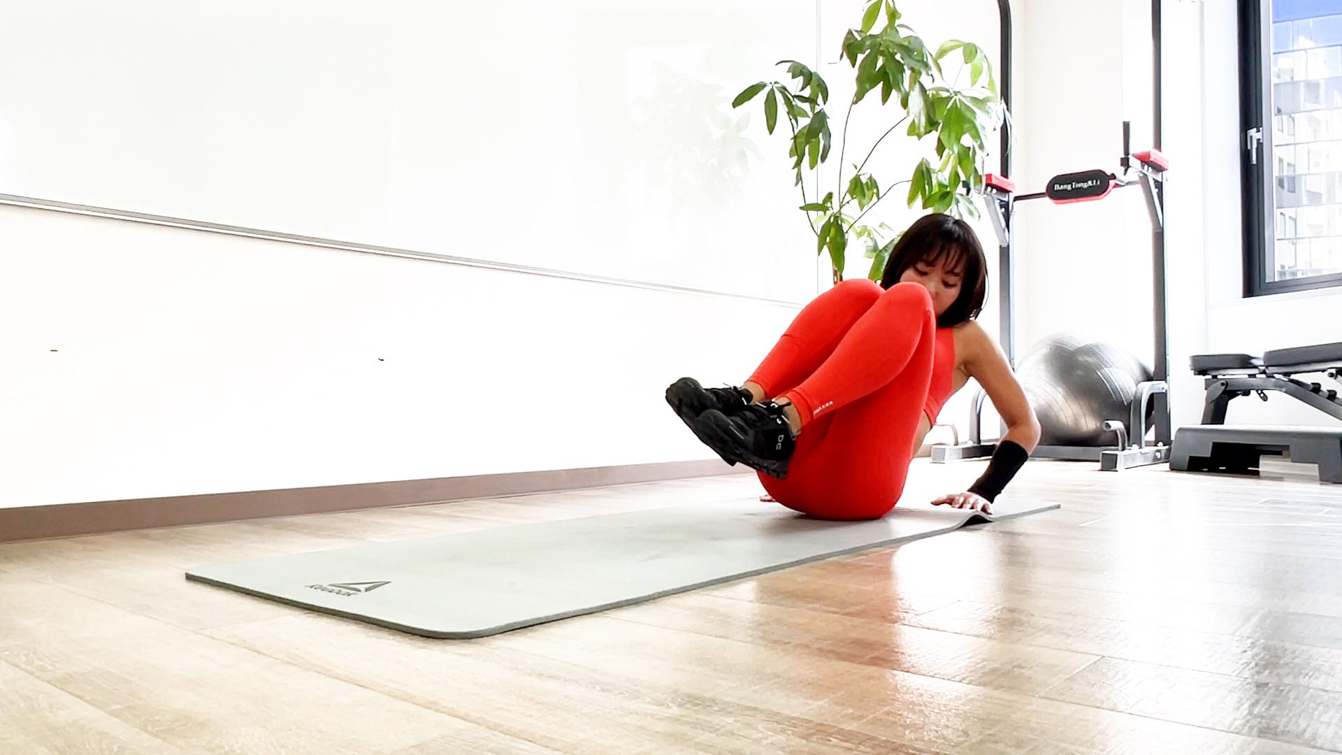 ツイストニートゥチェストの写真2　ひねるように膝を胸に引き寄せる