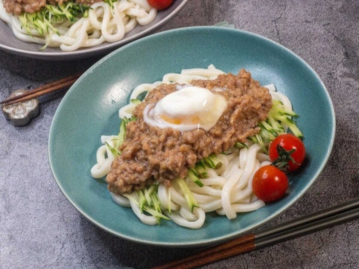 水色の器に豚そぼろと温泉卵が乗った冷やしうどん