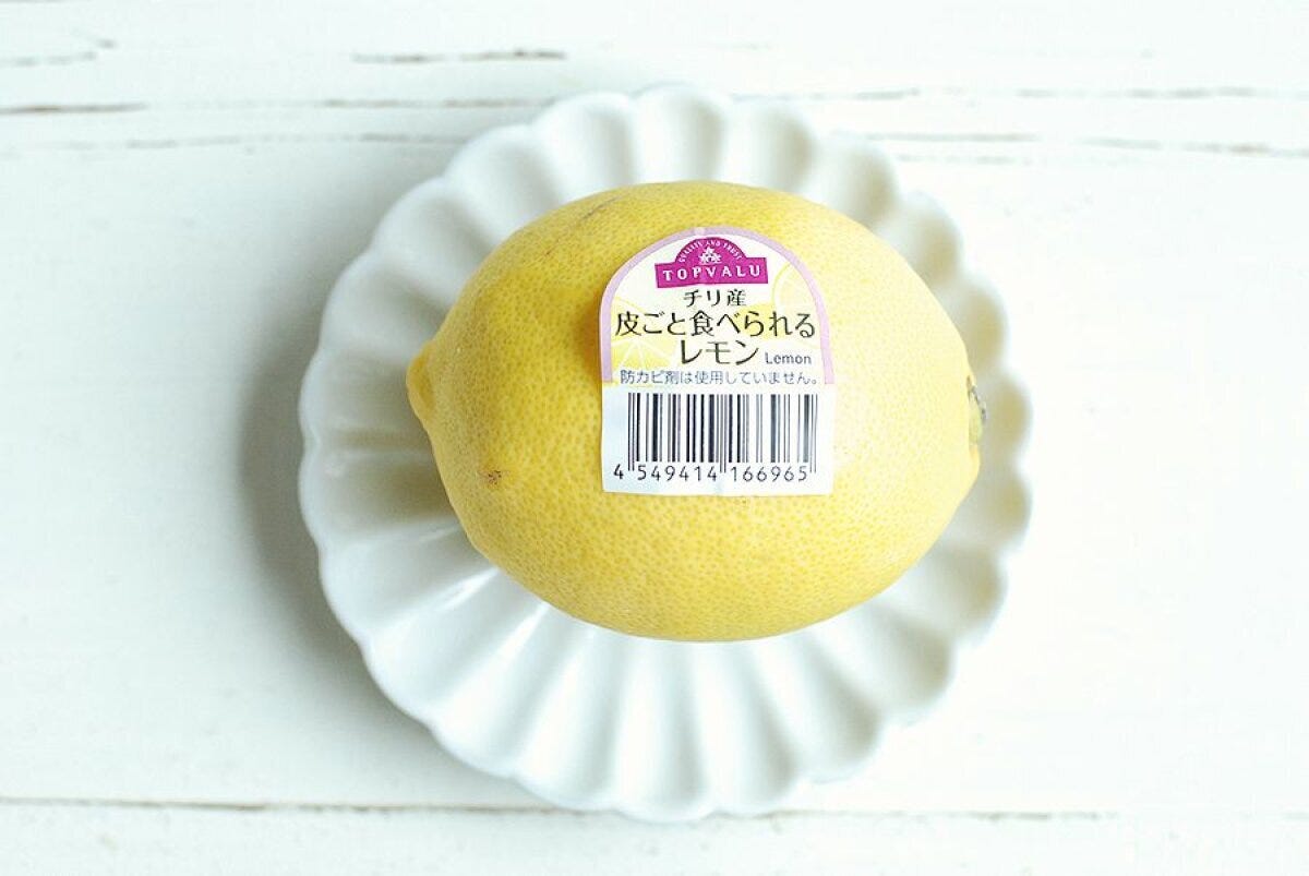 白い皿に乗せられた皮ごと食べられるチリ産レモンのアップ 白い皿に乗せられた皮ごと食べられるチリ産レモンのアップ