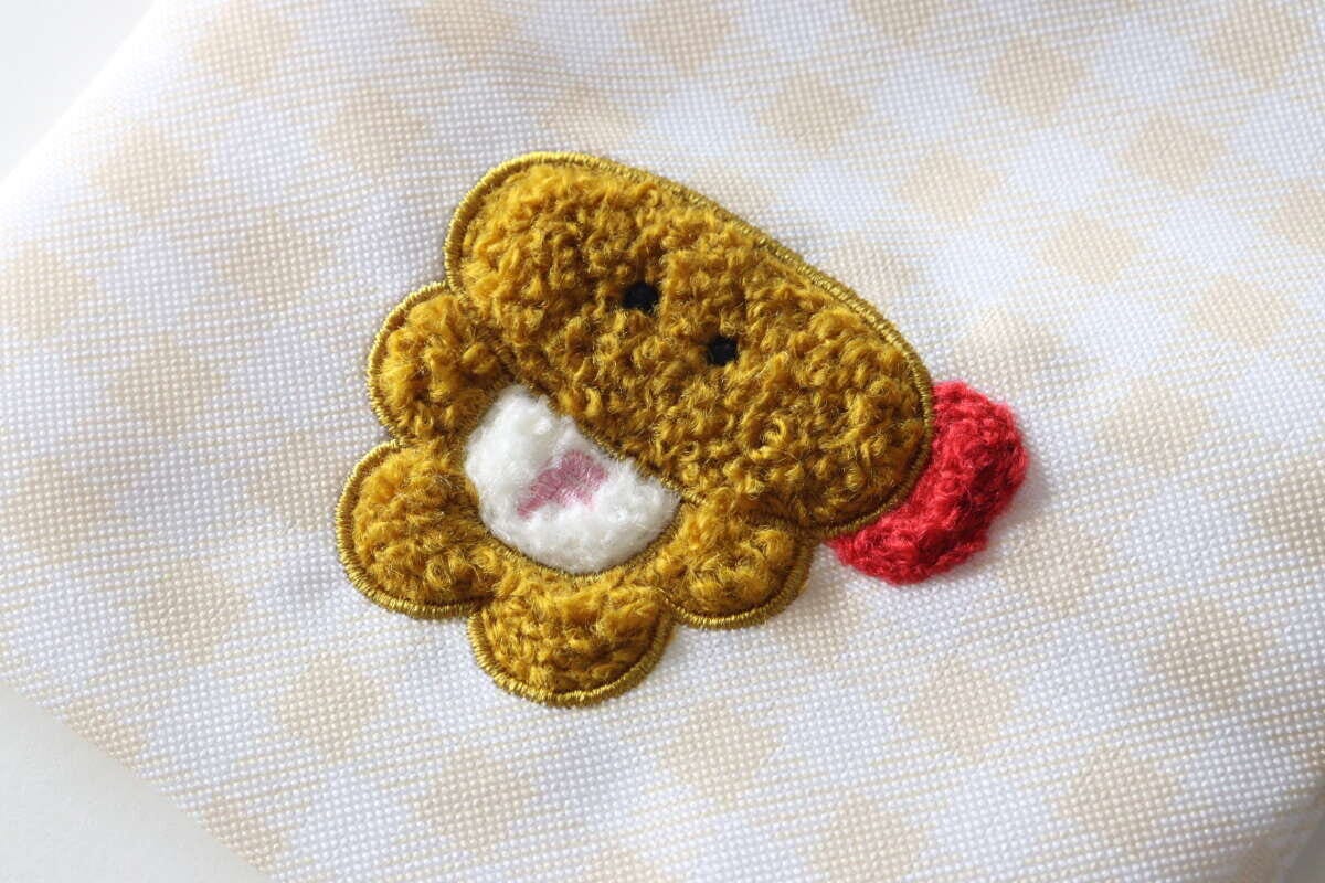 ダイソーのサガラ刺繍プチ巾着、エビフライ坊やの刺繍部分のクローズアップ ダイソーのサガラ刺繍プチ巾着、エビフライ坊やの刺繍部分のクローズアップ