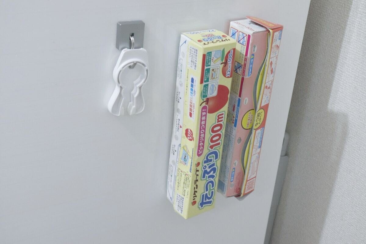 冷蔵庫の側面にラップの箱2つと白いフックが貼り付けられている