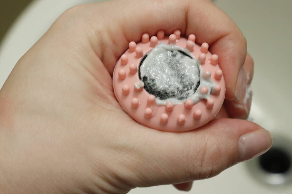 洗顔ブラシの底面に白い洗顔料が塗布され、泡立てる前の状態 洗顔ブラシの底面に白い洗顔料が塗布され、泡立てる前の状態