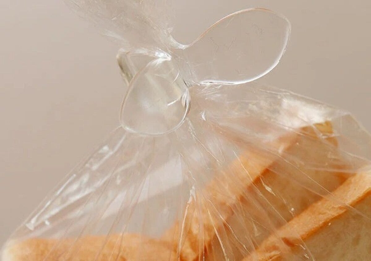 透明なウイングクリップで食パンの袋の口を留めている様子 透明なウイングクリップで食パンの袋の口を留めている様子