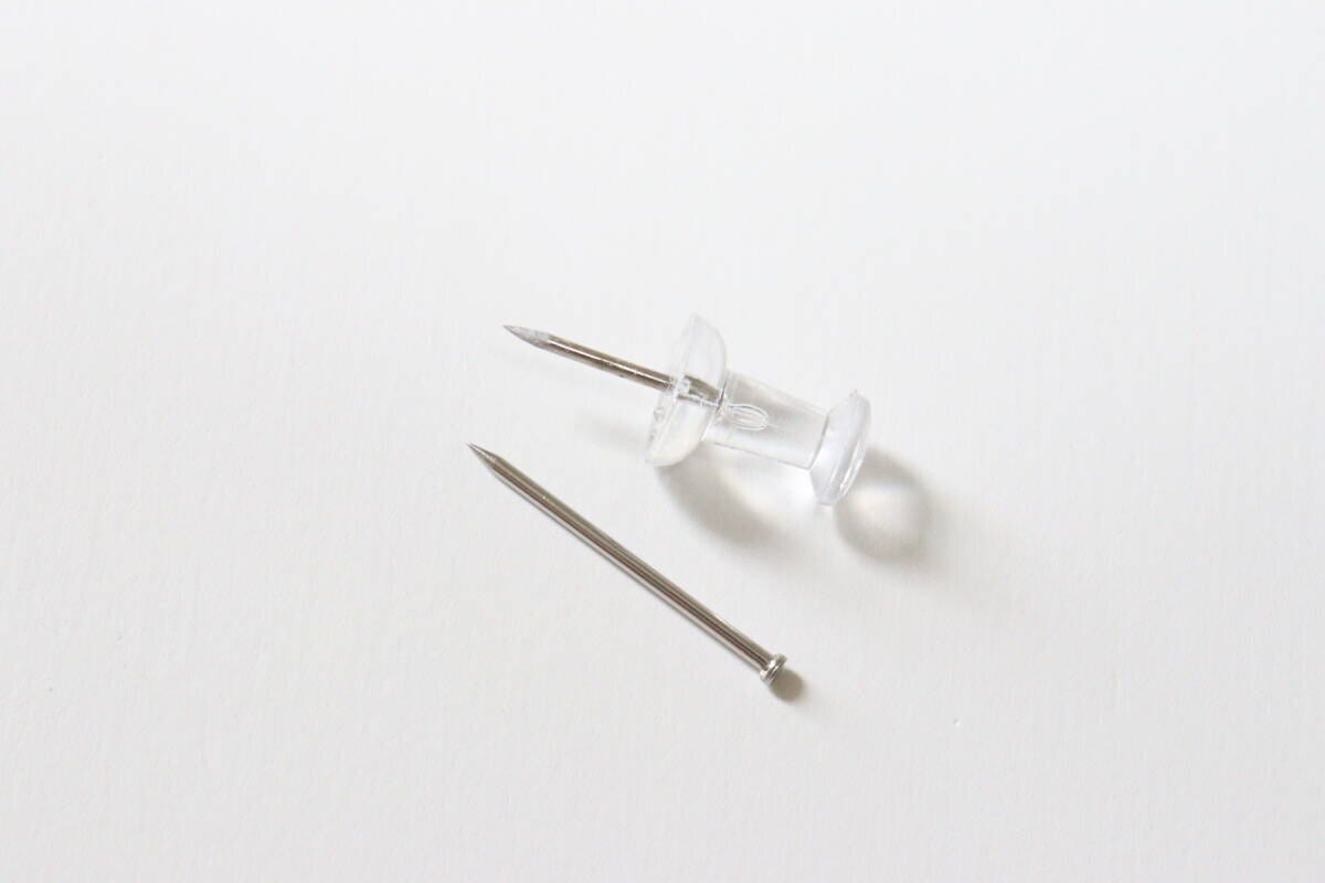 ダイソーの壁面に取り付けできるネジ型ピンと一般的な押しピンの太さを比較