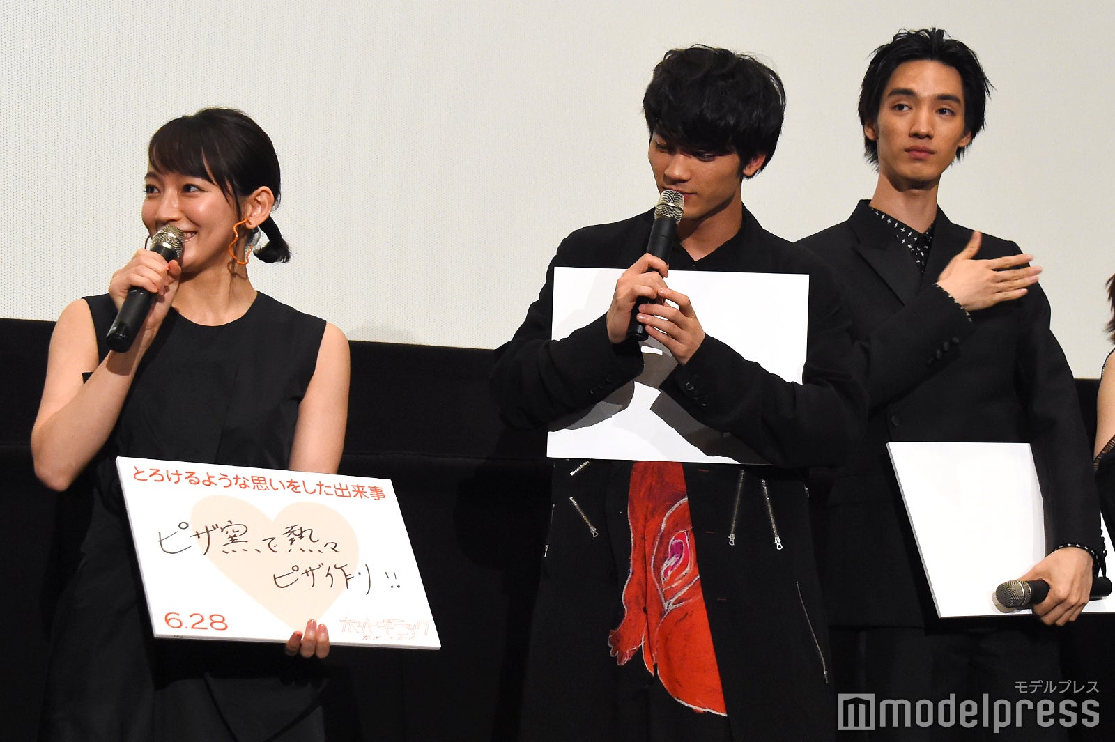 パネルの説明をする吉岡里帆、拍手する板垣瑞生、スーツについたホコリをはらう清水尋也 （C）モデルプレス