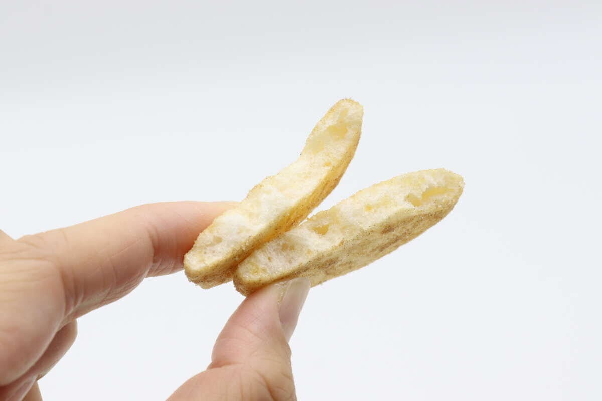 指でつまんだ2枚のファミマ味ソフトせんべい。表面に味付けが見える