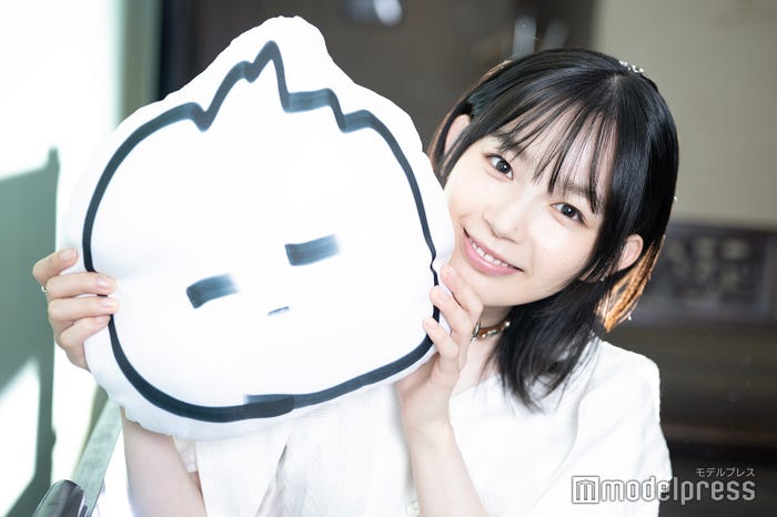 自身作のイラスト“とがるくん”のクッションを持つ宮崎優(C)モデルプレス