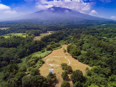 大森勝山遺跡の環状列石と岩木山。環状列石は77基の組石と約1,200個の石で造られている。出典：JOMON ARCHIVES（弘前市教育委員会撮影）