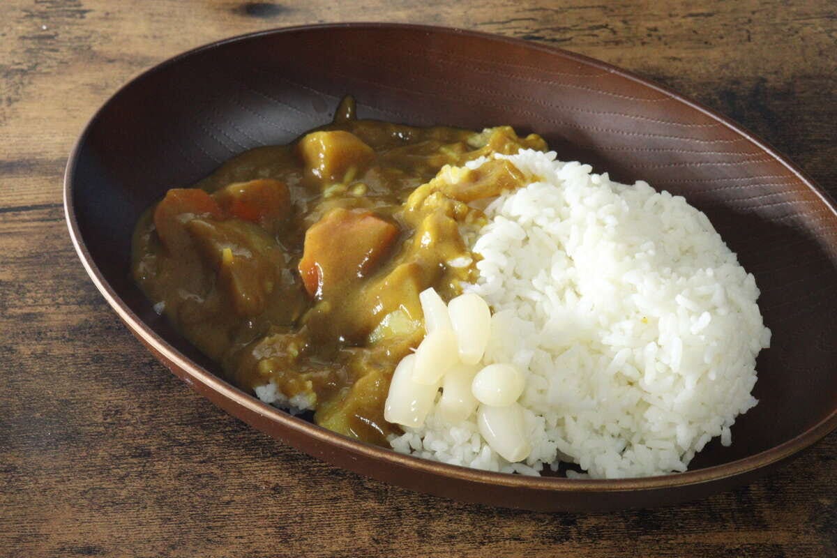 木目調の皿に盛られたカレーライスと、ご飯の横に添えられた花らっきょう 木目調の皿に盛られたカレーライスと、ご飯の横に添えられた花らっきょう