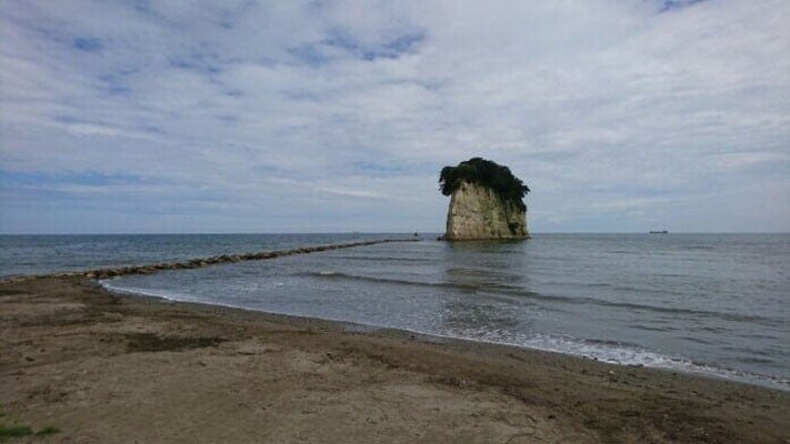 「軍艦島」の通称を持つ見附島。砂浜のすぐそばにあり、独特の形が目を引き付けます(2019年7月撮影)